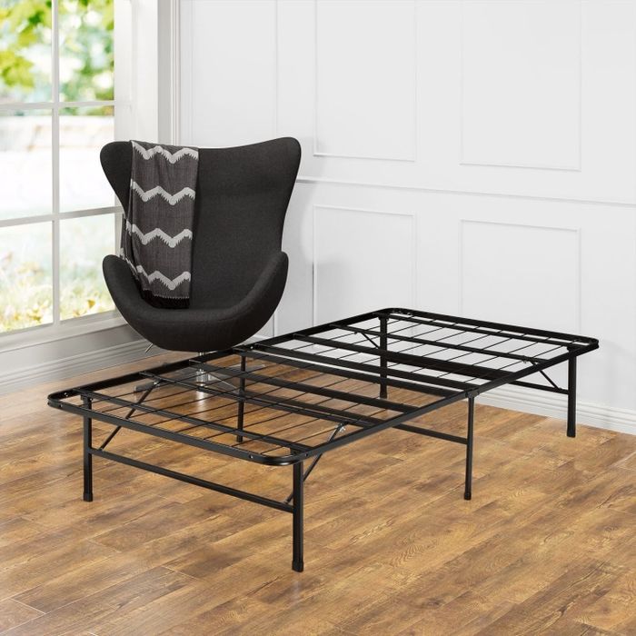 A sleek black metal bed frame placed in a bedroom setting