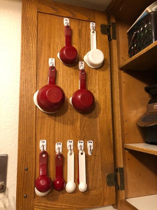 Measuring spoons and cups organized on the hooks.