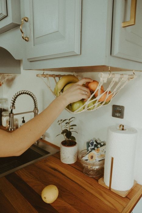 A kitchen featuring a fruit hammock suspended from the bottom of a cabinet