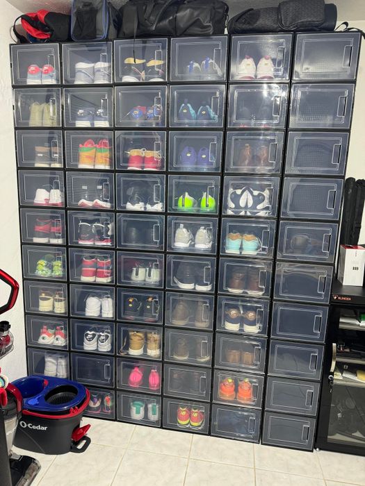 A wall featuring transparent shoe storage boxes neatly holding various sneakers, organized and ready for easy access.