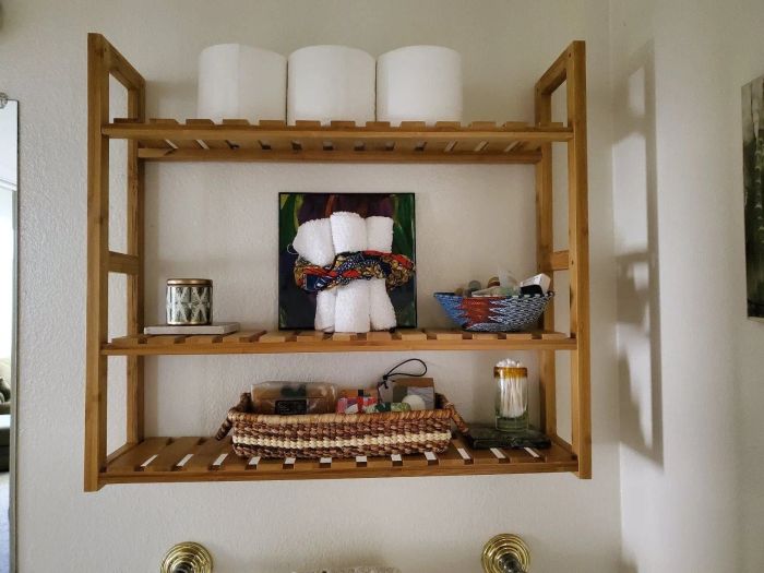 Another reviewer demonstrates the rack mounted on the wall, holding an assortment of bathroom essentials.