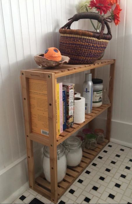A reviewer shows the rack placed on the floor, holding a variety of products.