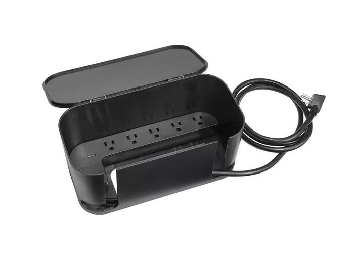 A cable management box with its lid open, showcasing a power strip with multiple outlets and a connected power cord.