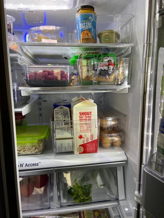 A refrigerator filled with a variety of food items like eggs, dairy products, and fresh produce, all neatly organized on its shelves