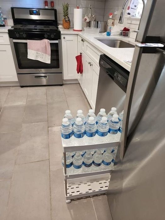A reviewer photo showing the storage unit neatly positioned between the kitchen cabinets and the fridge