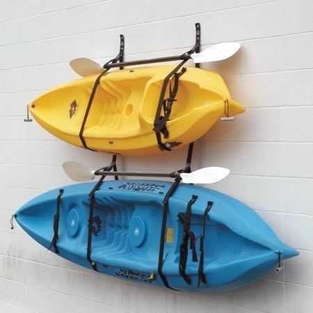 A photo of two kayaks securely hung on the wall using straps