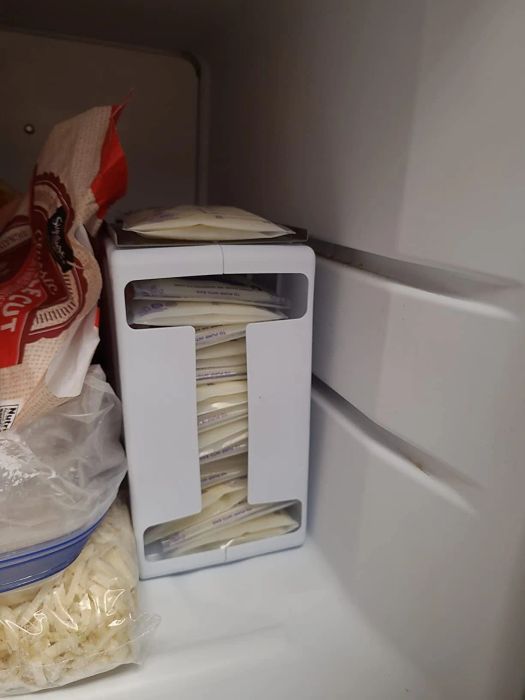 A freezer organizer with stacked breast milk storage bags alongside other frozen food items