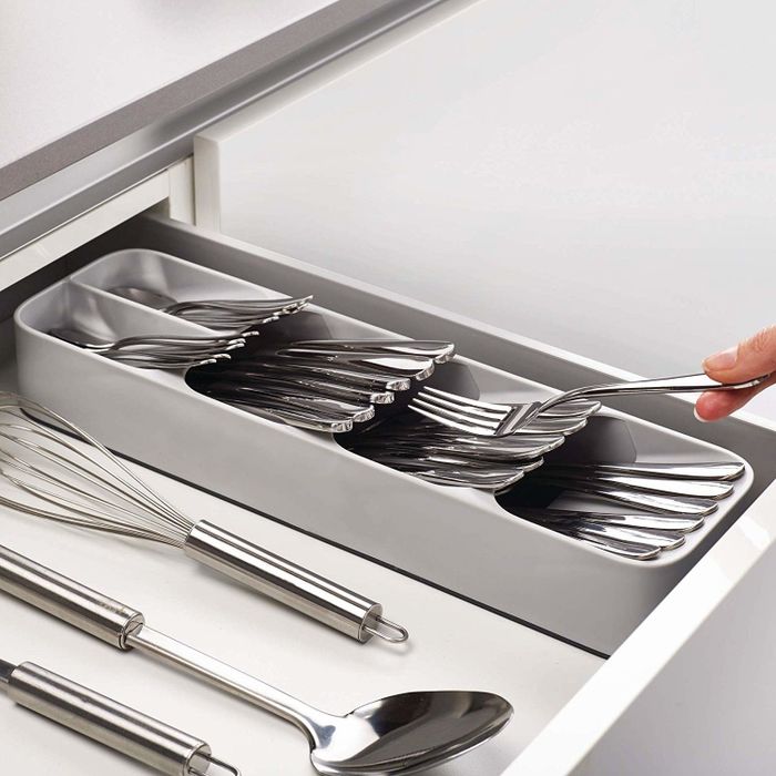 An open kitchen drawer showcasing a compact gray silverware organizer, leaving ample room for other kitchen tools in the same drawer