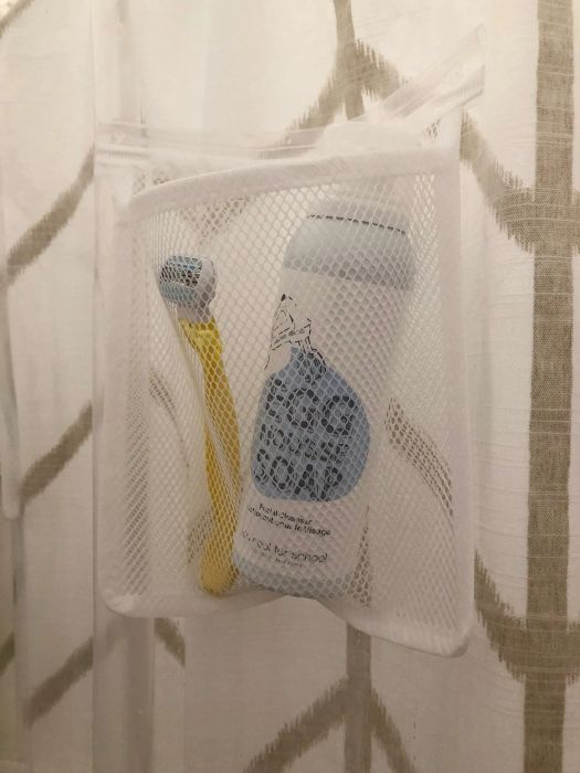 Close-up of one of the mesh pockets containing a razor and a large bottle of cleanser.