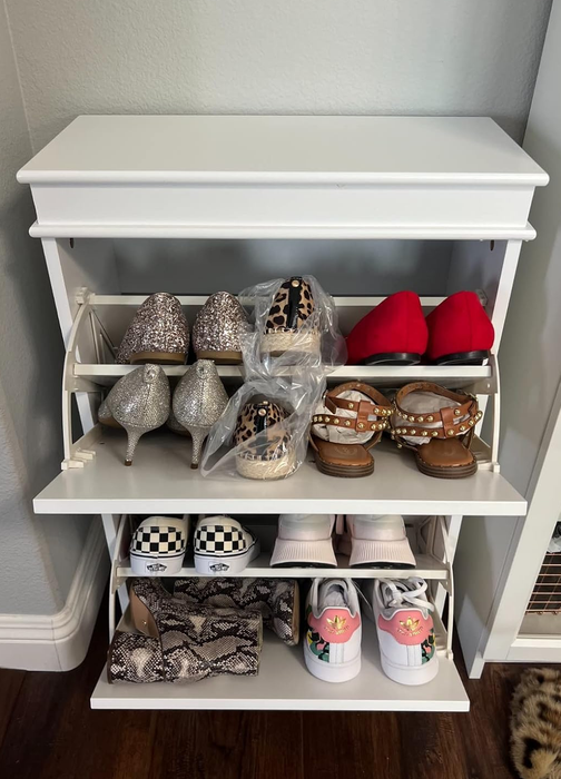 a reviewer's photo of the two-drawer cabinet with its compartments open, showcasing an assortment of shoes