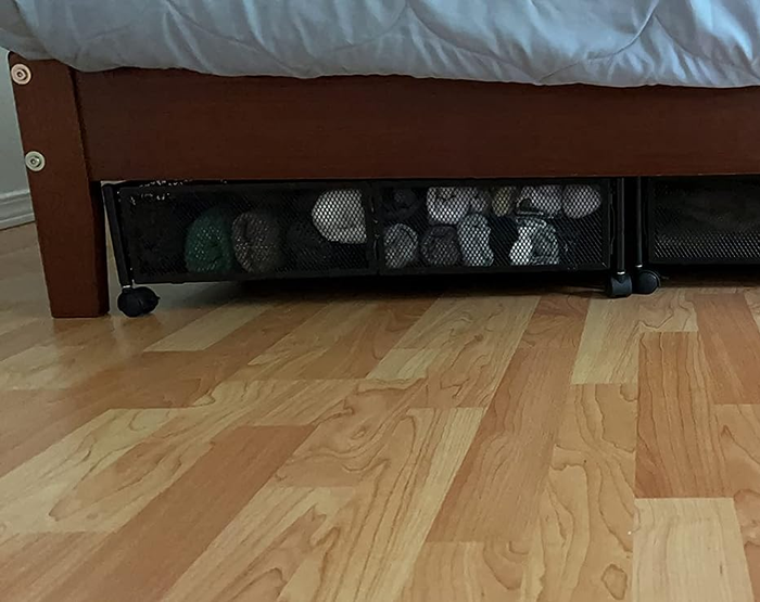 a reviewer's photo of the storage container tucked neatly under a bed