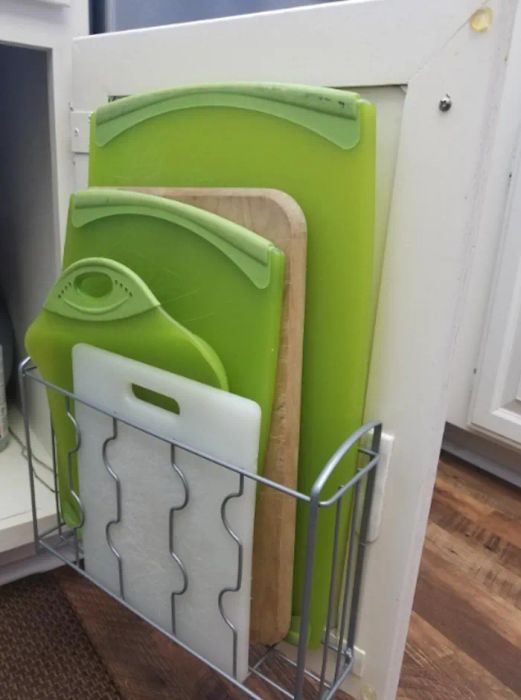 A different reviewer showcasing the organizer holding five cutting boards