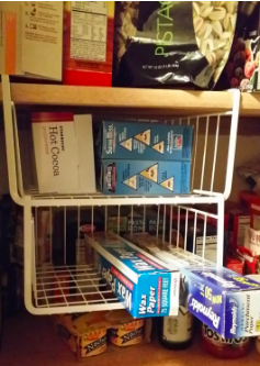 Another photo showing two under-shelf baskets in a pantry, neatly storing items like aluminum foil and making the most of empty space