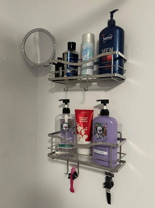 A shower shelf lined with grooming products such as Suave Men's shampoo and conditioner, along with a hanging razor for easy access.