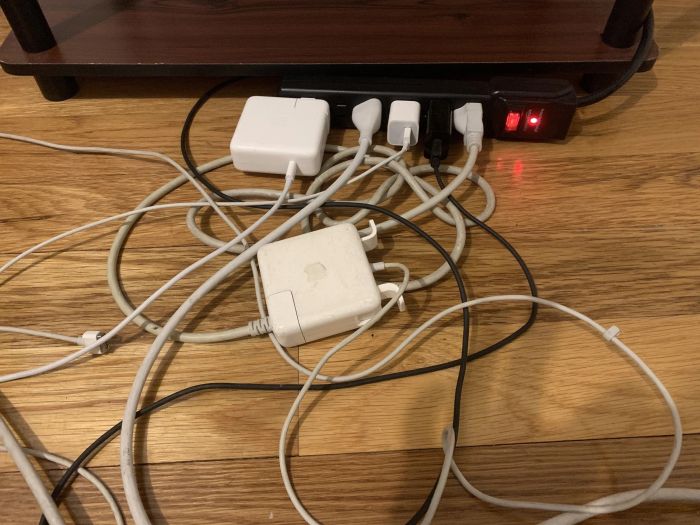 A pile of tangled cords plugged into a power strip, creating a messy situation.