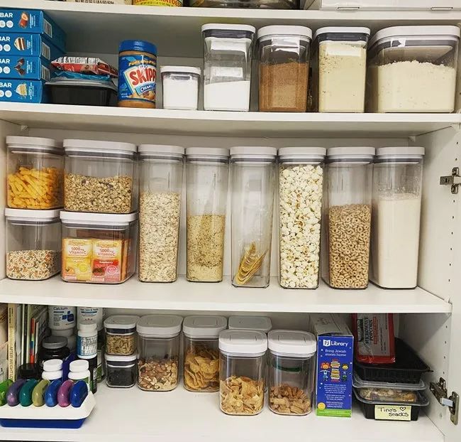 A reviewer's organized cabinet filled with neatly stacked OXO food storage containers.