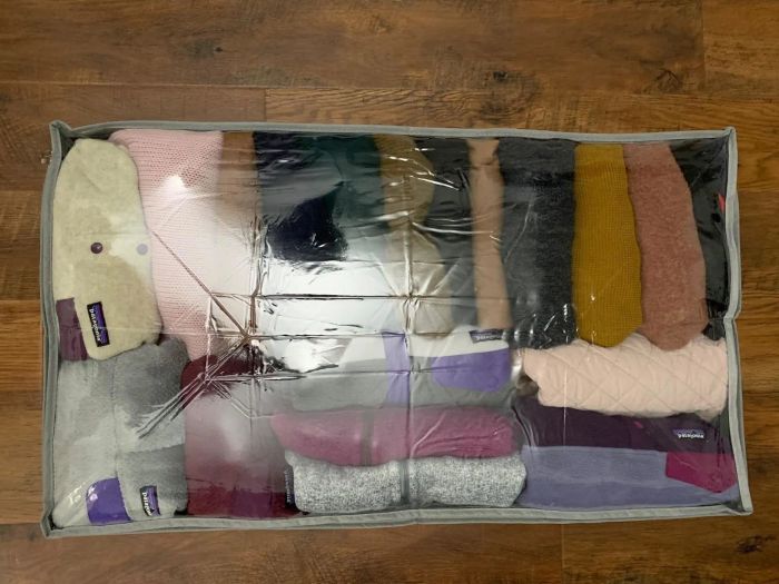 Reviewer photo showing an under-bed storage container filled neatly with sweaters and sweatshirts.