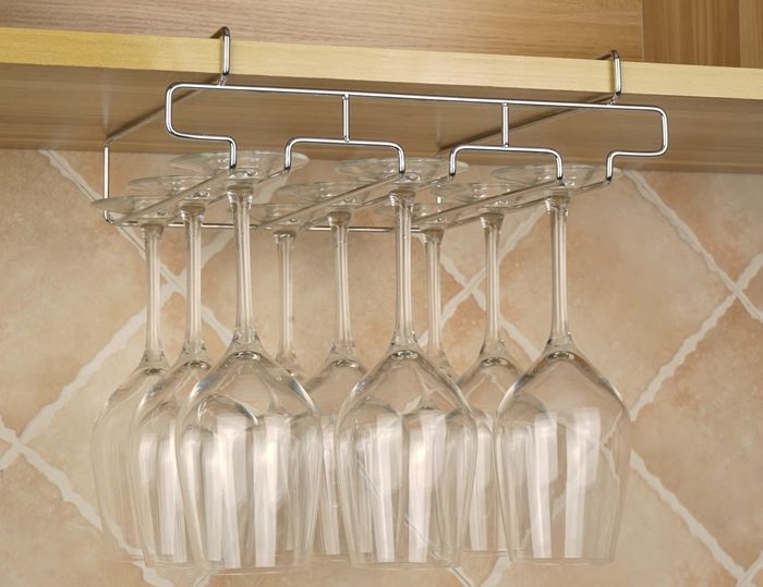 An under-cabinet wine glass holder with multiple rows, capable of storing up to nine glasses