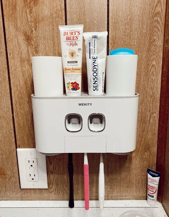A wall-mounted white toothbrush holder.