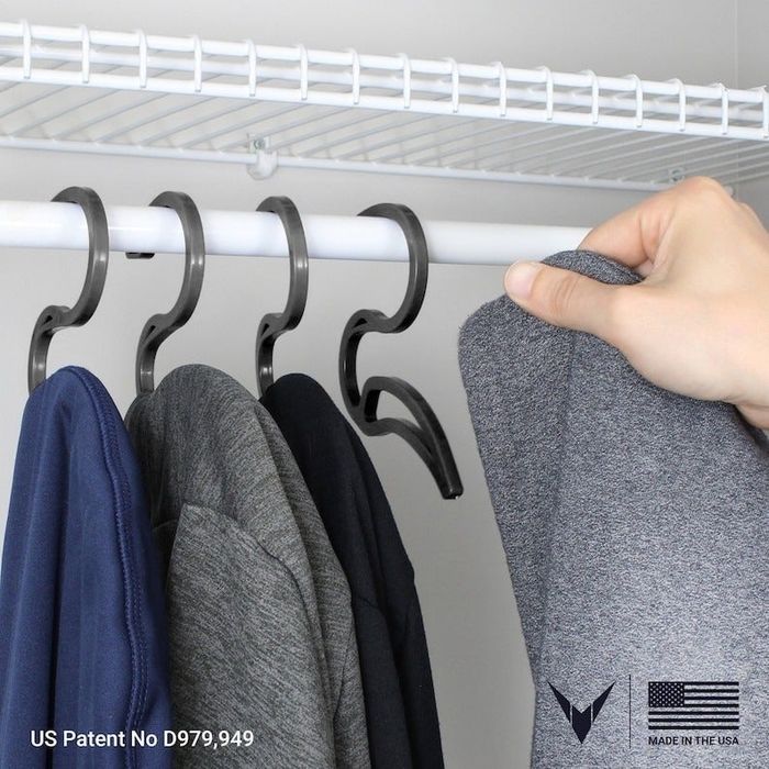 four hoodie hangers mounted on a closet rod, each holding a sweatshirt