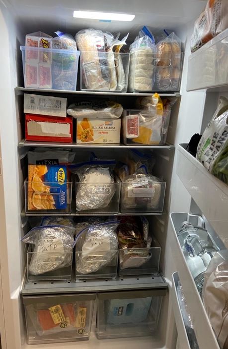 An open refrigerator showcasing neatly arranged food containers and packaged items. Great for those looking for ideas to organize their fridge efficiently