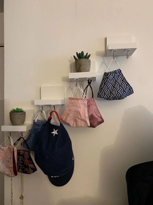 Masks, hats, and other items neatly suspended by the hooks.