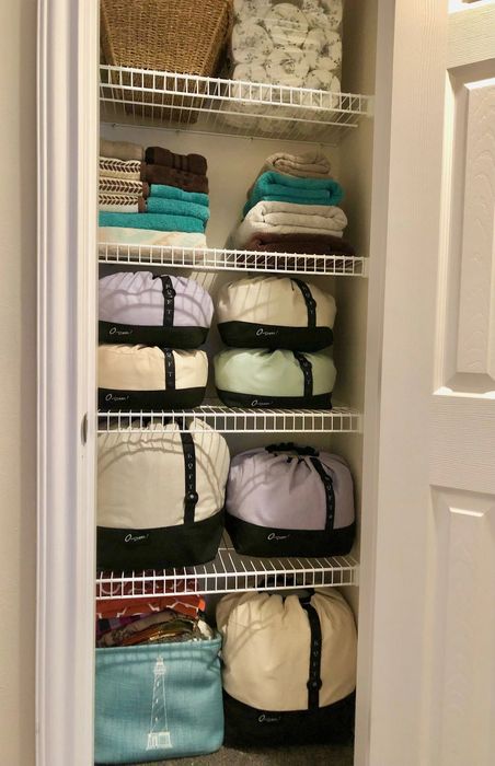 A closet featuring several O-Sheet bedding organizers neatly arranged inside