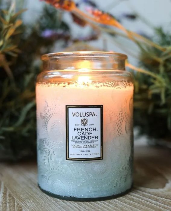 a tall glass candle jar featuring an intricate design