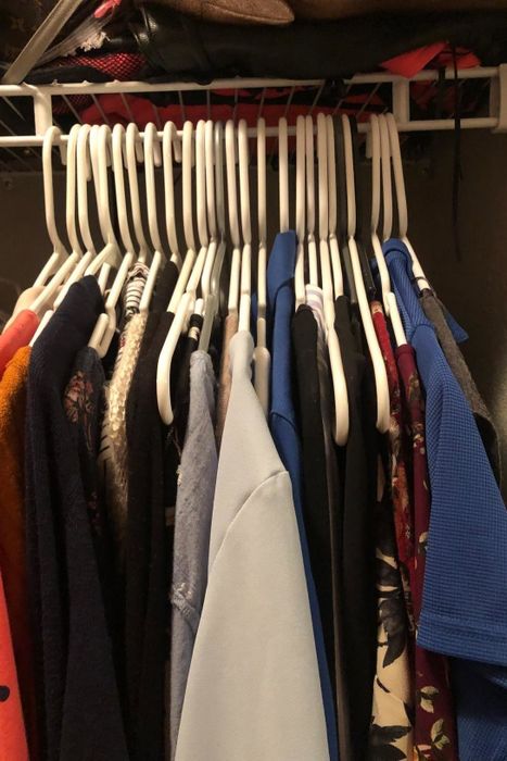 A reviewer's closet cluttered with numerous plastic hangers, taking up excessive space