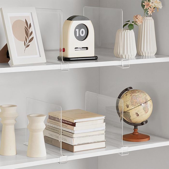 A bookshelf displaying modern decor items, each separated with acrylic dividers.