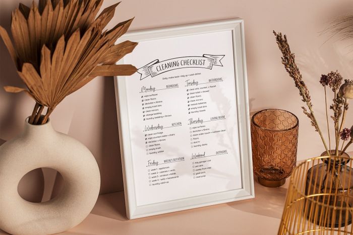 A printed checklist with each room assigned a specific day of the week, complete with tasks to clean and organize that room.