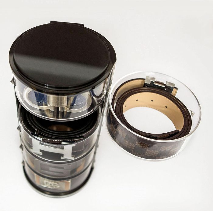 top view of acrylic belt organizer with one compartment open, showcasing a belt inside