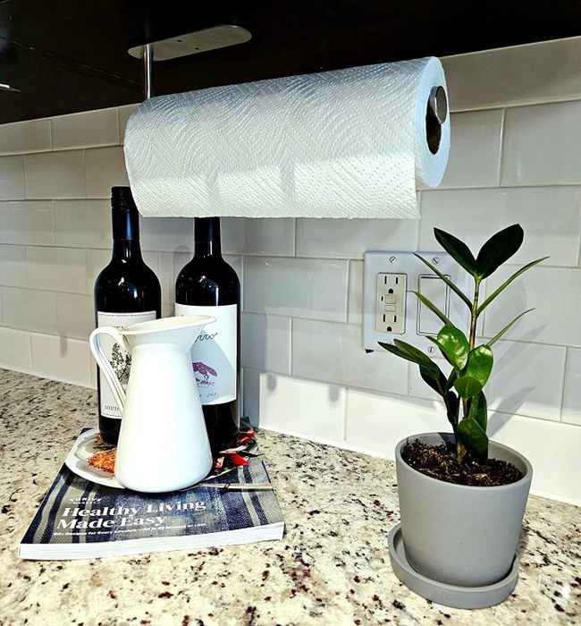 A photo showing the paper towel holder installed underneath the reviewer's cabinet.