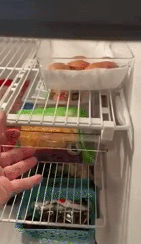 A reviewer demonstrating the convenience of opening a drawer inside their fridge.