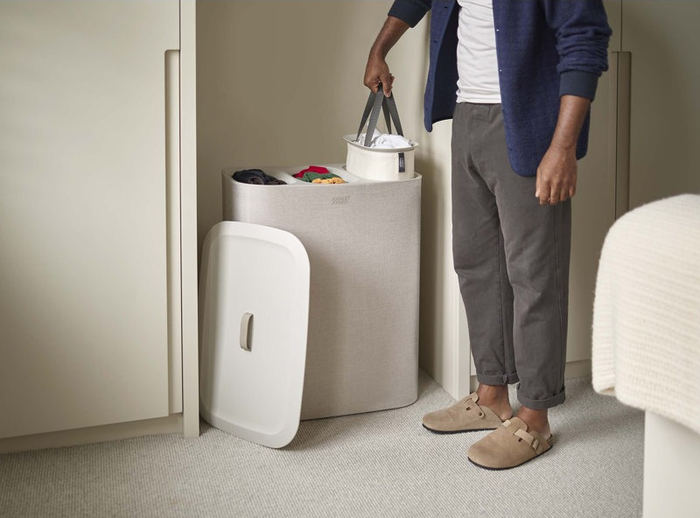 A model picking up one of the laundry bins.