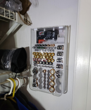 A reviewer’s photo showing the battery organizer securely mounted on the wall of their garage