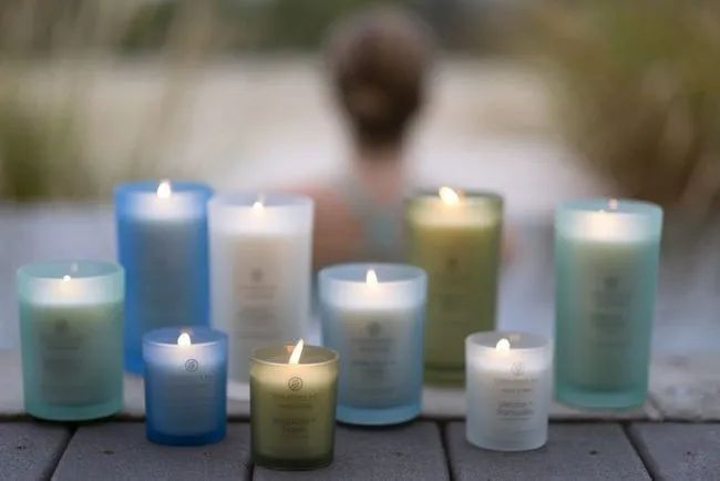 candles available in different sizes, housed in frosted colored glass