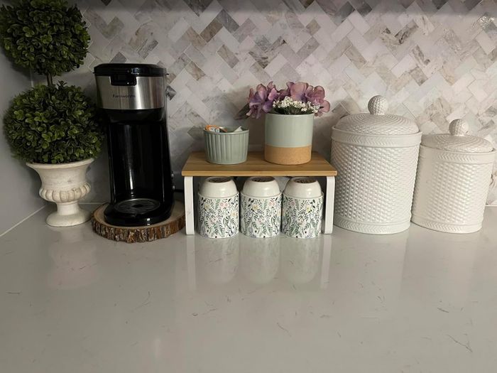 A reviewer’s countertop featuring the shelf, with a plant placed on it.