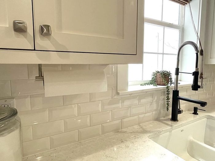 A review shows the paper towel holder mounted under a cabinet