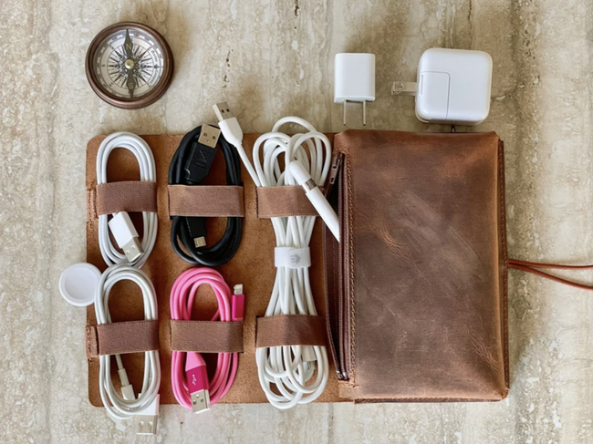 The leather organizer neatly holding several cords.