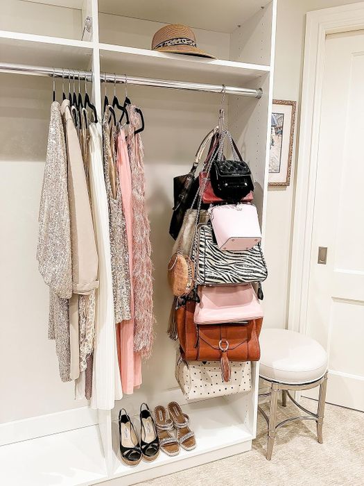 The purse organizer hanging in a closet, holding multiple handbags.