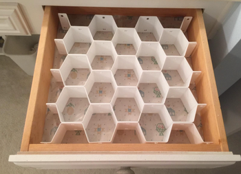 A reviewer's photo showing the honeycomb drawer organizer inside a dresser drawer, arranged neatly.