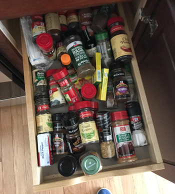 A clutter of spices in a drawer.