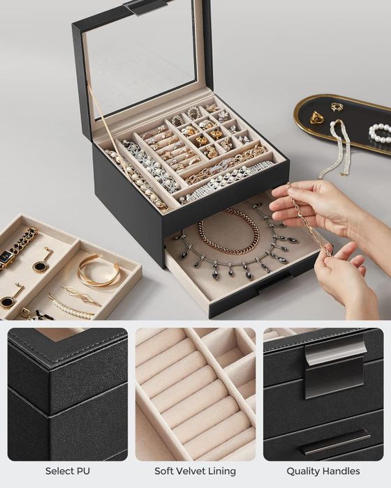 A jewelry box with distinct compartments for different items, shown with hands arranging a necklace. Inset images emphasize features like select PU material, soft velvet lining, and durable handles.