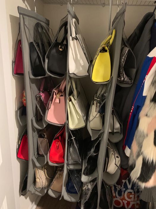 A reviewer’s closet showing three hanging bag organizers holding various bags
