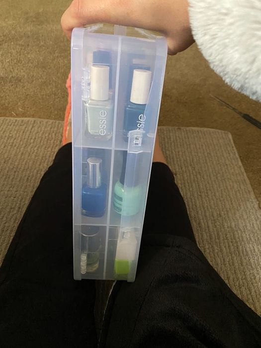 Reviewer displaying the side of the nail polish holder container.