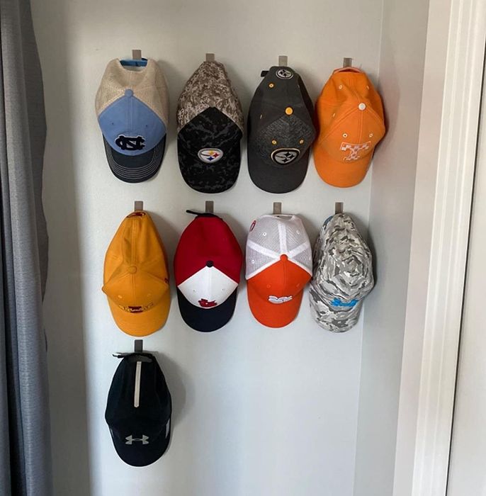 Reviewer shows their collection of nine baseball caps hanging neatly on the wall hooks