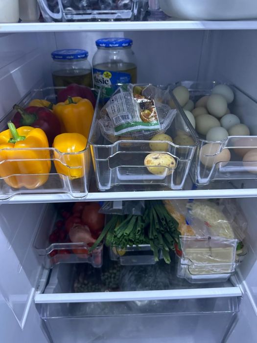 Another shot of the reviewer’s fridge with clear bins neatly organizing the items.