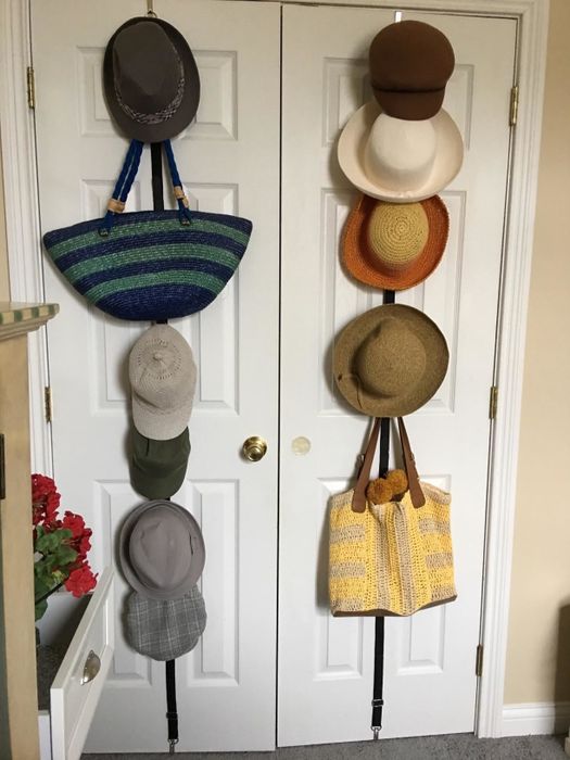 Another reviewer's photo of the organizer holding different types of hats and purses