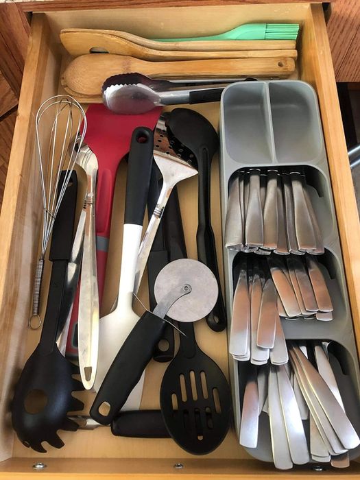 A reviewer's photo showing the silverware organizer alongside other kitchen utensils neatly arranged in a drawer